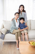 © Blue Jean Images - Happy Chinese family relaxing on sofa