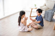 © Blue Jean Images - Happy Chinese sibling playing in living room