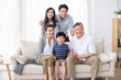 © Blue Jean Images - Happy Chinese family relaxing on sofa