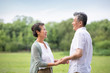 © Blue Jean Images - Happy senior Chinese couple holding hands on grass