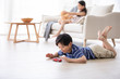 © Blue Jean Images - Happy Chinese sibling playing with toys in living room