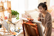 © Blue Jean Images - Young Chinese woman painting at home