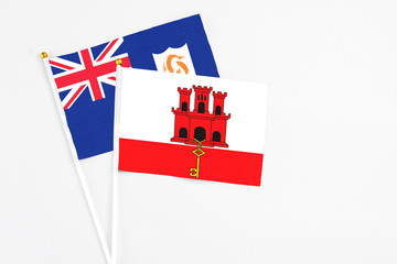 Gibraltar and Anguilla stick flags on white background. High quality fabric, miniature national flag. Peaceful global concept.White floor for copy space.