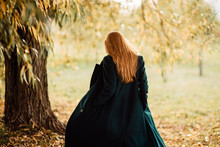 Beautiful Young Girl With Red Hair And In Long Coat Is Resting In The Park, Woman Walking Outdoors