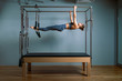 © Georgii - Palates trainer girl posing for a reformer in the gym. Fitness concept, special fitness equipment, healthy lifestyle, plastic. Copy space, sport banner for advertising.