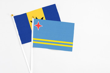 Aruba and Barbados stick flags on white background. High quality fabric, miniature national flag. Peaceful global concept.White floor for copy space.