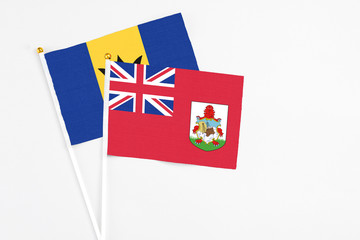 Bermuda and Barbados stick flags on white background. High quality fabric, miniature national flag. Peaceful global concept.White floor for copy space.