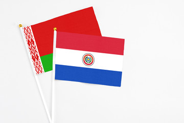 Paraguay and Belarus stick flags on white background. High quality fabric, miniature national flag. Peaceful global concept.White floor for copy space.