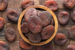 chocolate dried apricots in wooden bowl, top view.