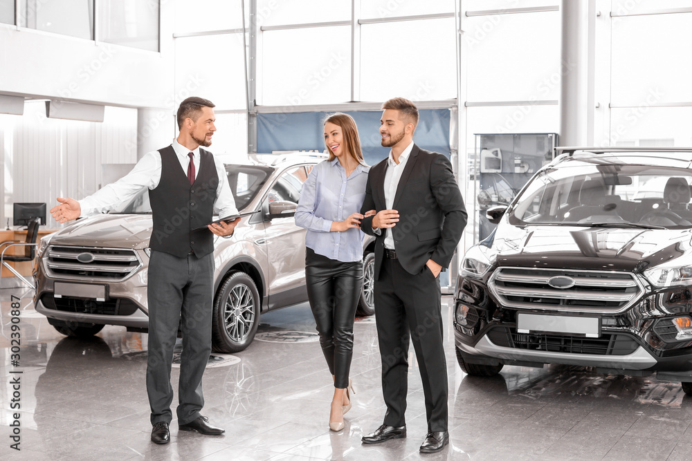 Couple buying new car in salon
