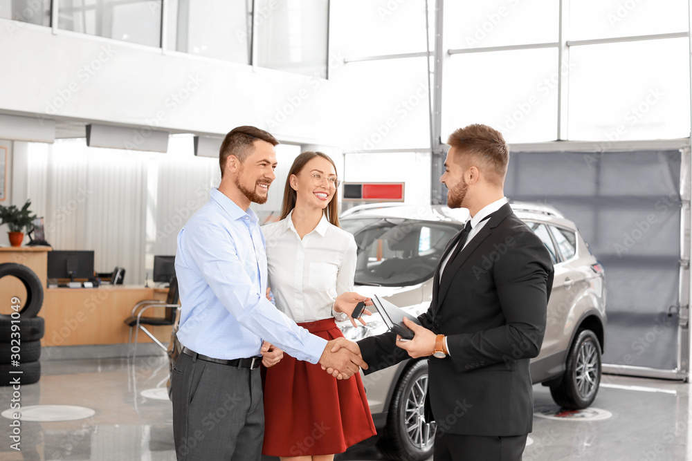 Couple buying new car in salon