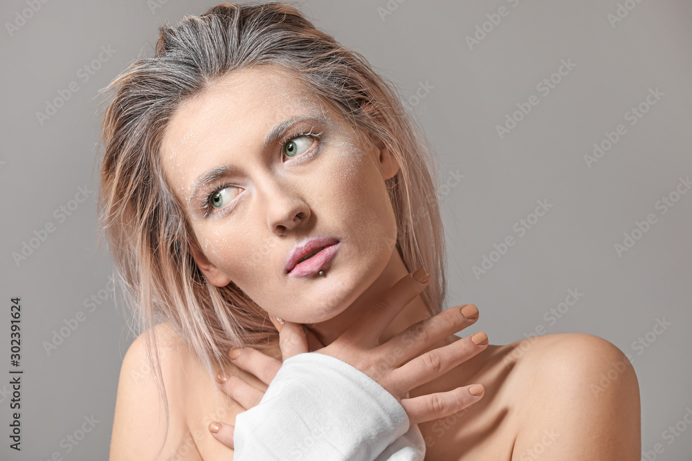 Beautiful woman with creative makeup on grey background