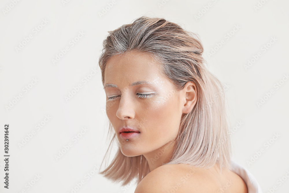 Beautiful woman with creative makeup on white background