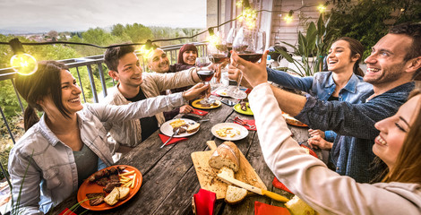 Sticker - Young people having fun toasting red wine together at dinner party in outdoor villa - Happy friends eating bbq food at restaurant patio - Millennial life style concept on warm retro filter - Wide view