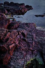 Wall Mural - Red cliffs by the sea with soft evening light