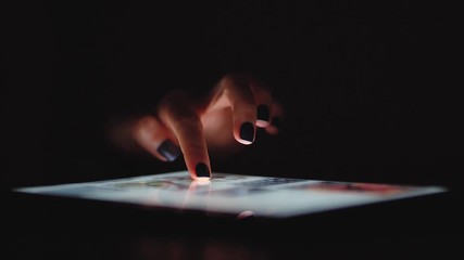 Woman using digital tablet at night shopping online from home