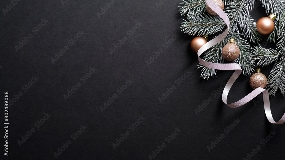 Christmas banner. Christmas tree branch decorated copper color balls and ribbon on black background. Flat lay, top view. Xmas banner mockup with copy space. - obrazy, fototapety, plakaty 