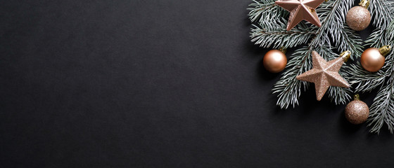 christmas banner. black xmas background with pine tree branch decorated cooper color balls and stars