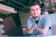 © familylifestyle - Optimistic smiling disabled man with amputated two stump hands in cafe looks at camera. Invalid freelancer works on laptop. Portrait of playful smiling young handicapped guy person with disabilities.