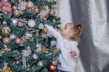 Little cute girl near the Christmas tree . New year and Christmas. Christmas tree decoration.