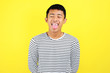 © Heru - Portrait of funny young Asian man sticking tongue out happy with funny expression