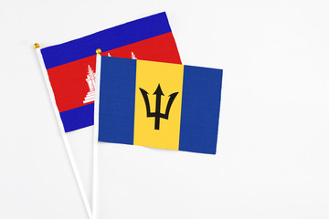 Barbados and Cambodia stick flags on white background. High quality fabric, miniature national flag. Peaceful global concept.White floor for copy space.