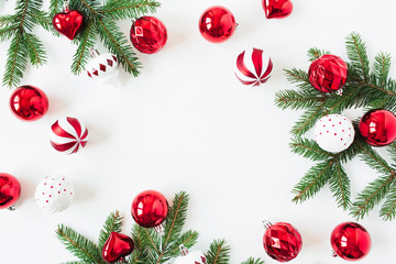 Christmas / New Year composition. Mock up frame with blank copy space made of fir needle branches, Christmas baubles / balls, decorations on white background. Flat lay, top view holiday concept.