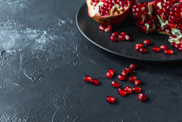  ripe red pomegranate on and grain on a gray background