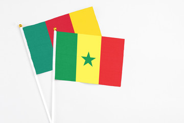 Senegal and Cameroon stick flags on white background. High quality fabric, miniature national flag. Peaceful global concept.White floor for copy space.