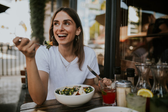 young woman eating salat in a restaurant