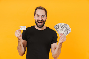 Wall Mural - Image of masculine man wearing t-shirt holding money cash and credit card