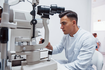 Wall Mural - Oculist tests vision of patient by using special modern machine