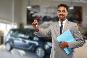 Sticker - auto business, sale and people concept - happy indian car dealer showing key over showroom background