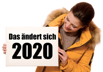 Poster - Fröhliche junge Frau hält Schild: Das ändert sich 2020