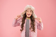 Warm smile. happy child pink background. warm clothes for cold season. kid fashion. trendy girl look like hipster. autumn style. Childhood activity. fur earflap hat accessory. small girl winter hat
