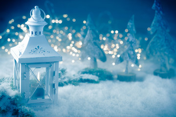 Wall Mural - vintage christmas lantern with burning candle in grey blue snow landscape with magic bokeh lights - 