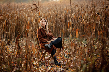 Sticker - Style woman with book sitting on chair on corn field in autumn time season