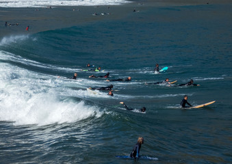 Islares, Spain , 29 September 2019 Wide surf beach of Islares with surfers riding through  waves in Cantabria, Spain.