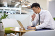 © Blue Jean Images - Young Chinese businessman using laptop in office