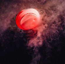 A Household Home Fire Detector Alarm On The Ceiling In A Darkened Room At Night Detects Rising Smoke To Protect People Asleep In Their Home.