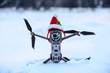 Drone in Santa Clause hat on snow