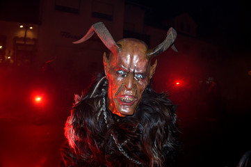 Unidentified person wearing a scary mask on a traditional parade named Krampuslauf in Austria during the christmas period