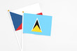 © sezerozger - Saint Lucia and Cyprus stick flags on white background. High quality fabric, miniature national flag. Peaceful global concept.White floor for copy space.