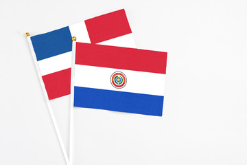 Paraguay and Dominican Republic stick flags on white background. High quality fabric, miniature national flag. Peaceful global concept.White floor for copy space.