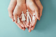 © SewcreamStudio - hands holding paper family cutout, family home, adoption foster care, homeless charity ,family mental health, international day of families, Autism support, domestic violence,parents day concept