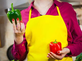 Woman holding two bell peppers