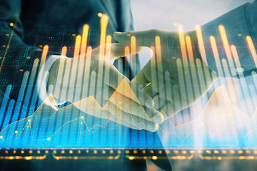 Double exposure of financial graph on cityscape background with two businessman handshake. Concept of stock market deal