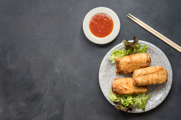 Wall Mural - fried vegetable spring rolls with fresh ingredients served and sour sauce in an oriental restaurant