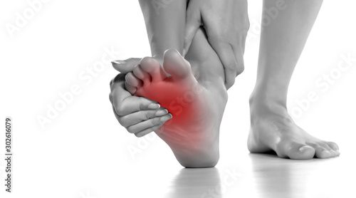Fotomural woman massaging her painful foot on white background