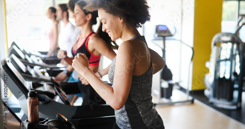 Fotomural Group of people exercising in a gym cardio training and running
